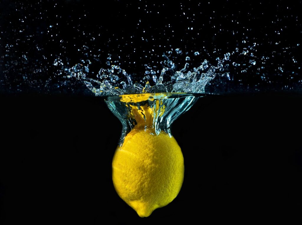 An Image of a lemon dropping in water.