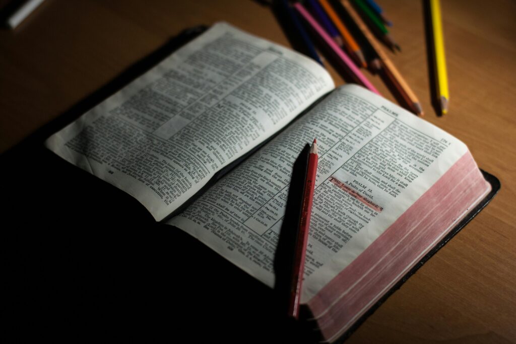 Image of open bible with pencils on a table.