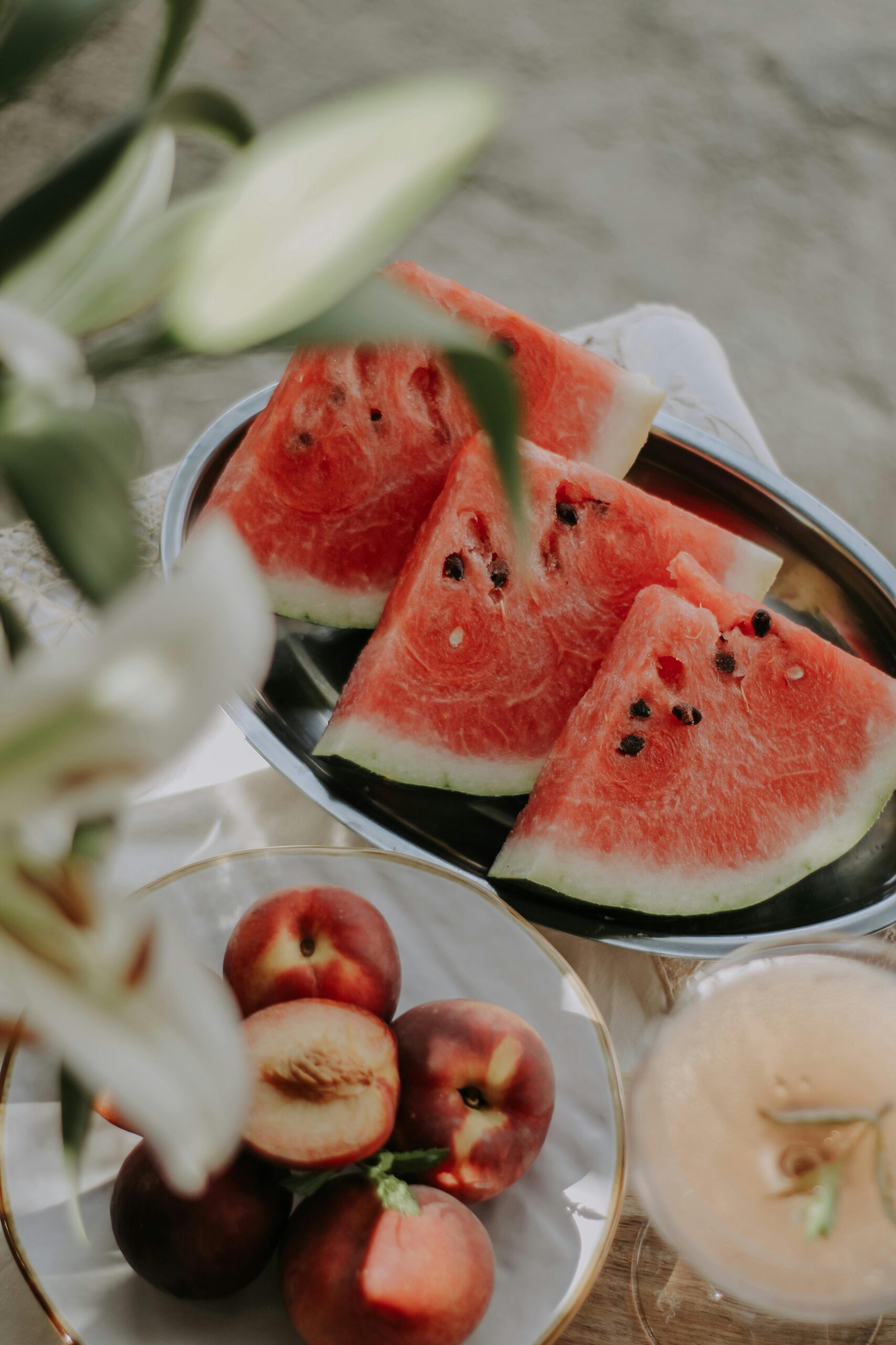 An image of watermelon, plum, and fruit on a table.