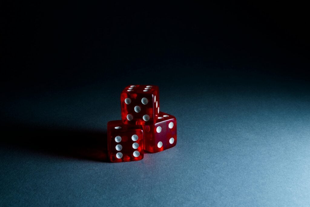 Red dice stacked on a dark surface.