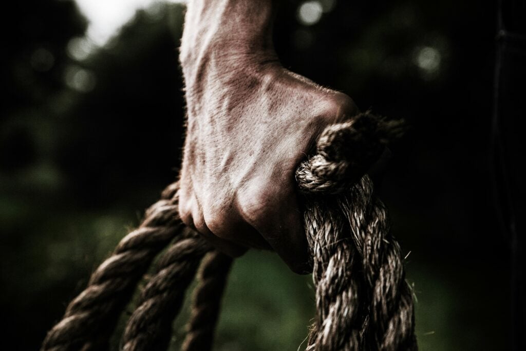 Man hands holding a rope.