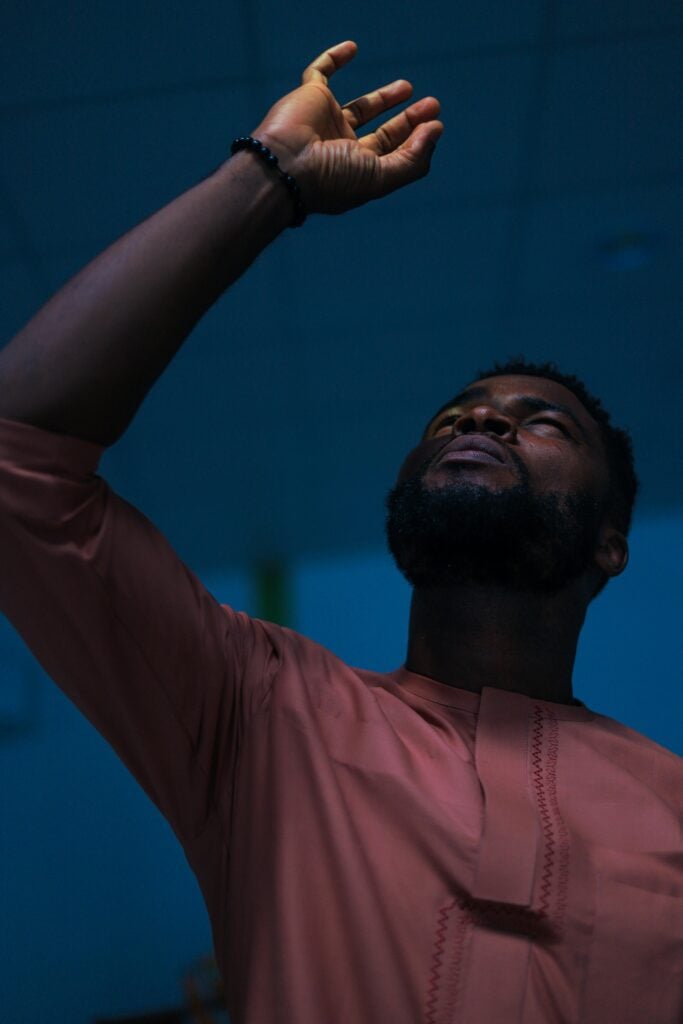 A man looking up and raising his hand.