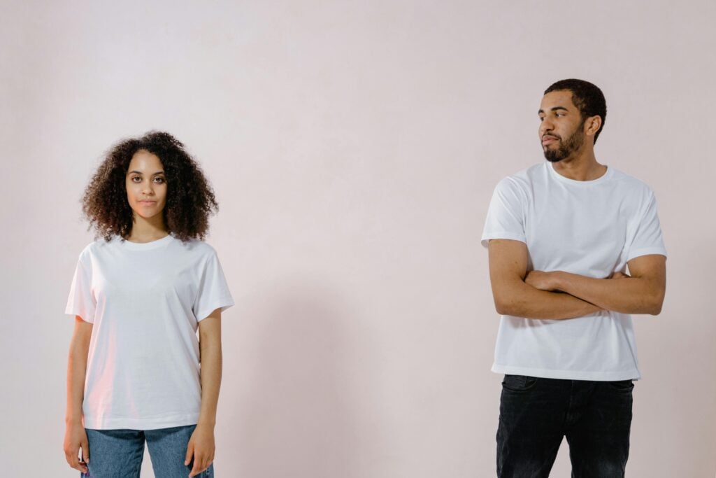 A man and woman standing at a distance in a disagreement.