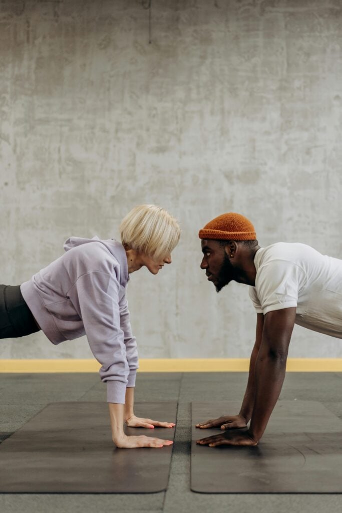 A woman and man in a "push up" position facing each other.