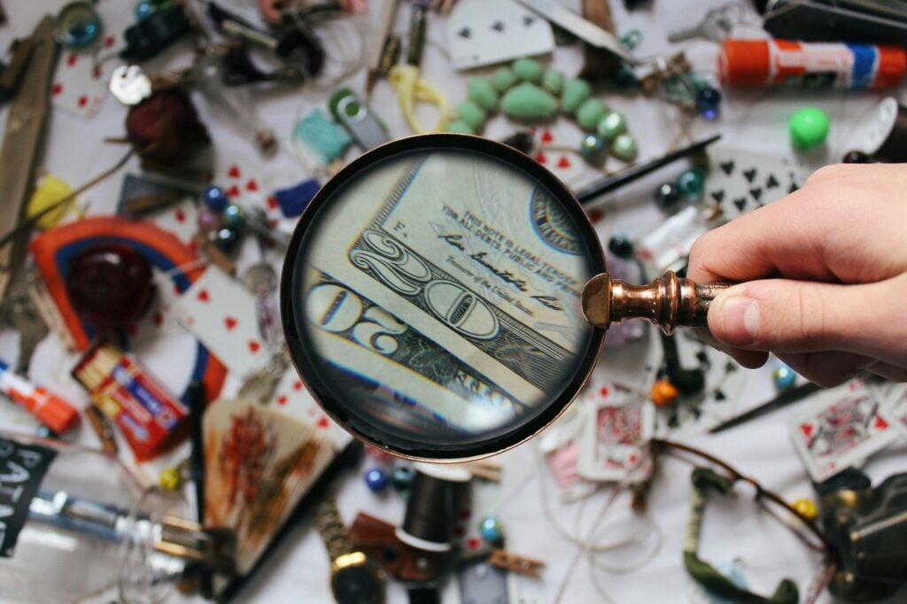 A magnifying glass that's looking at things on a surface highlighting money.