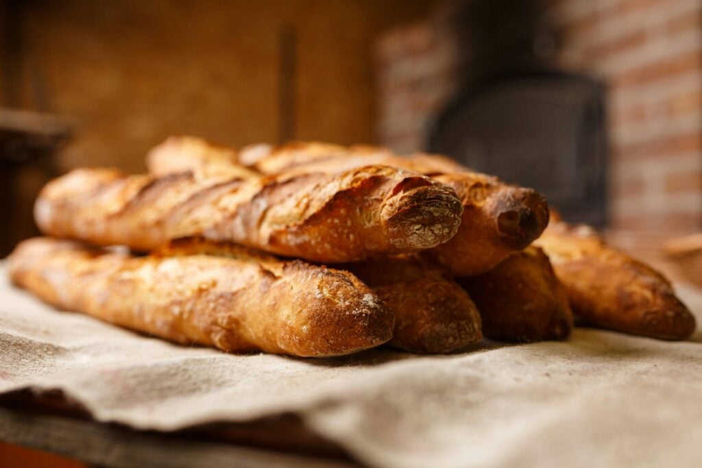 Freshly baked bread stacked on a cloth.