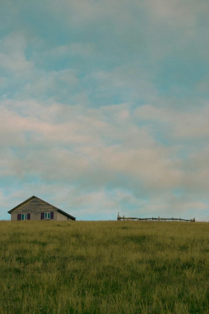 A house surrounded by a lot of land and grass.