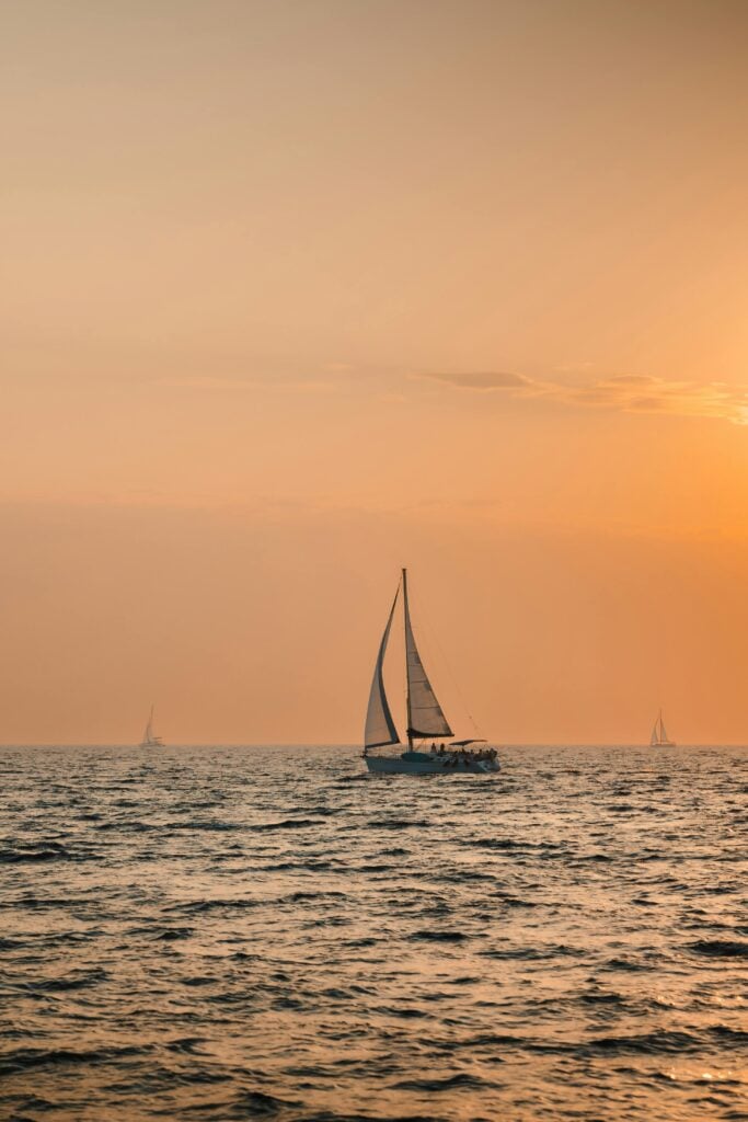 A boat sailing on the water at sunset.
