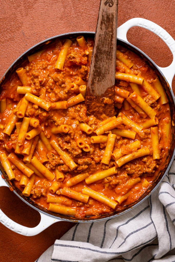 My Childhood Homemade Beefaroni in a pot with a wooden spoon.