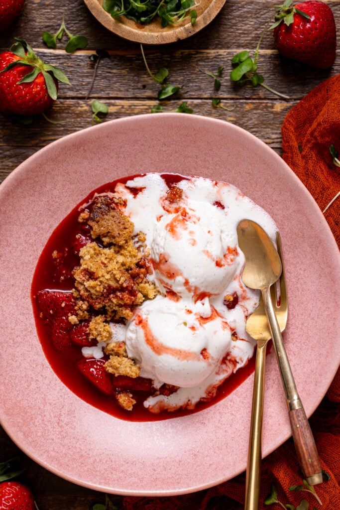 Strawberry Crumble For Two in a bowl with a fork and spoon.