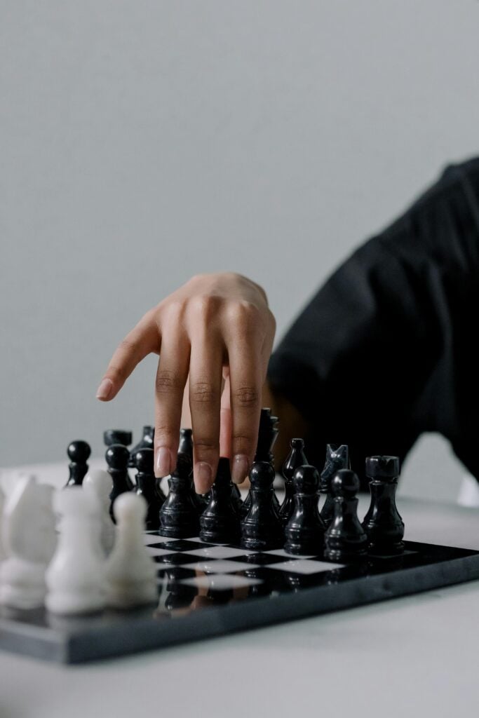 A chess game with someone's hands.