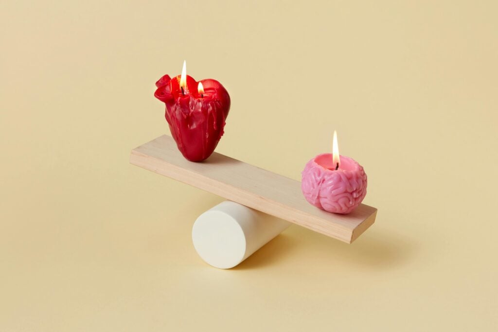 A heart and brain candle on a see-saw.