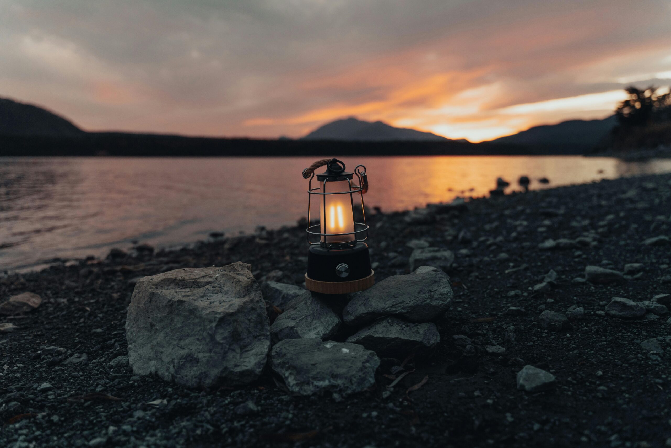 Lamp on a rocky area near water.