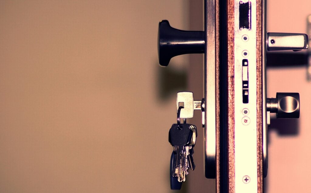 An opened door with a group of keys hanging in door.