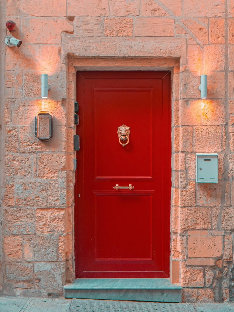 A red door with pink brick walls.