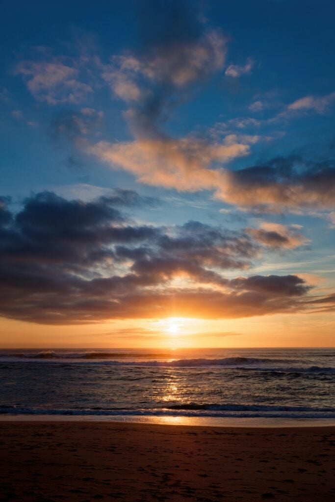 A beautiful sunset in the sky over water.