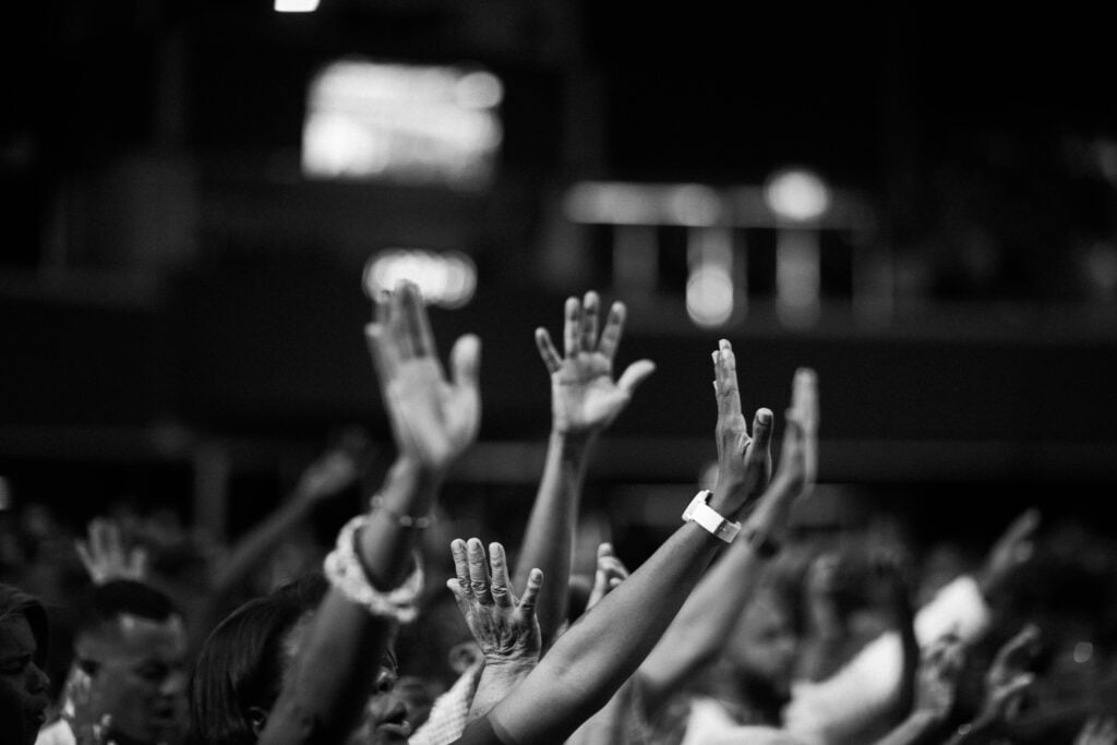 Hands lifted in a sanctuary in surrender to God.