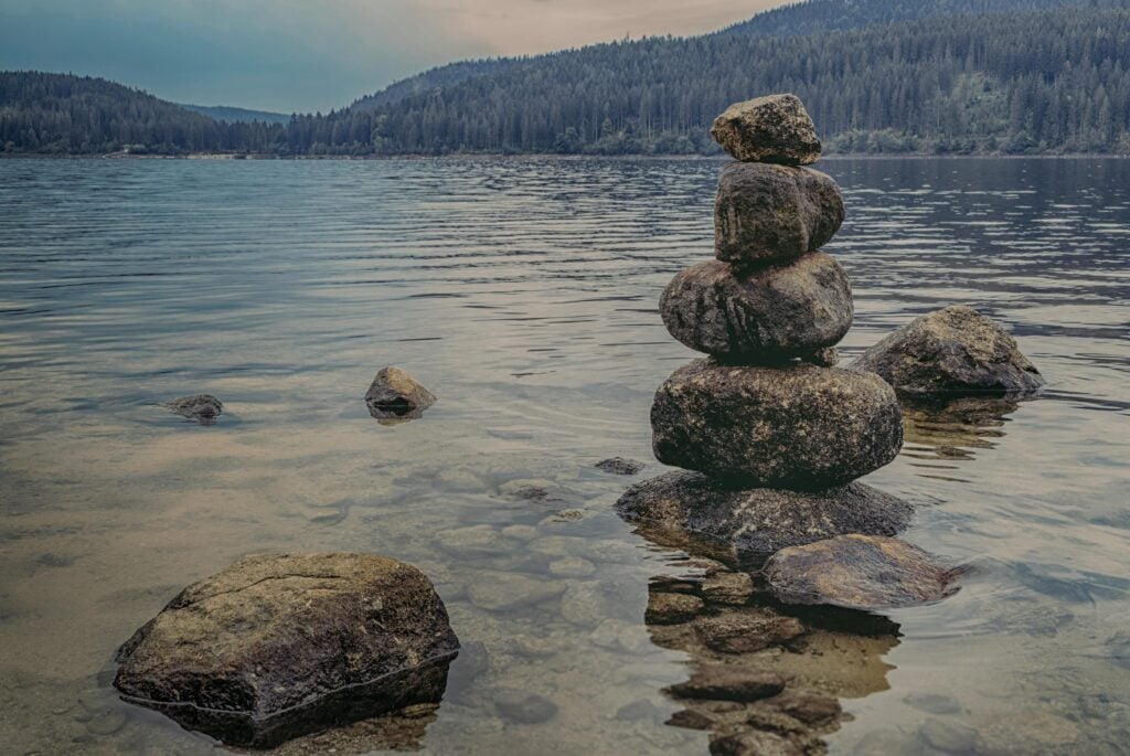 Stacks of large stones near water.