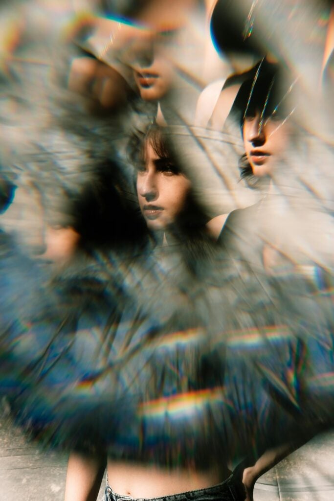 Someone's reflection within a broken or jaded mirror.