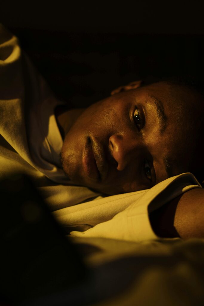 A man laying down looking downward.