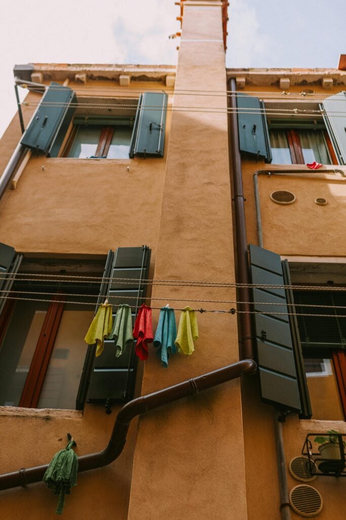 Image of housing complex with clothing lines and opened windows.