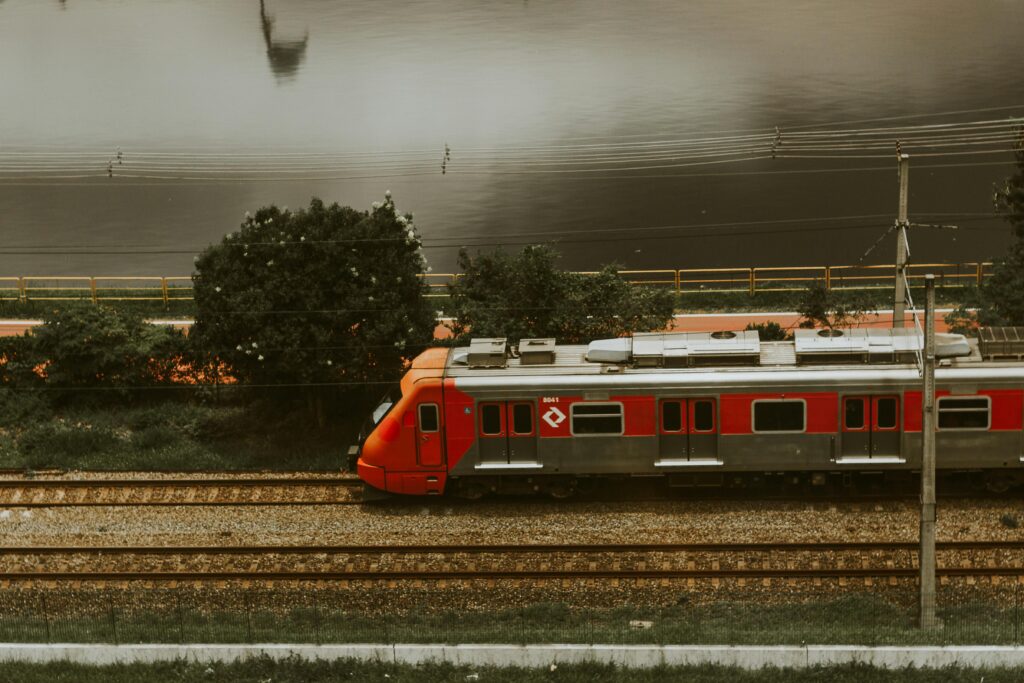 Side view of moving train on tracks with trees and other scenery.