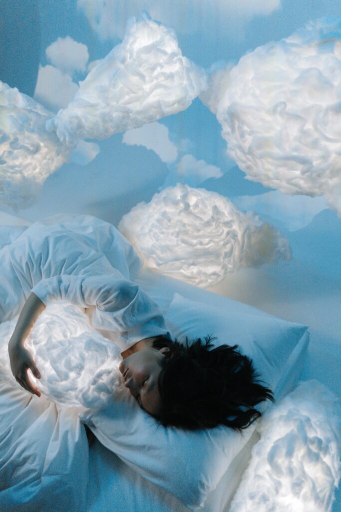 Image of a woman sleeping on a pillow with clouds surrounding her.