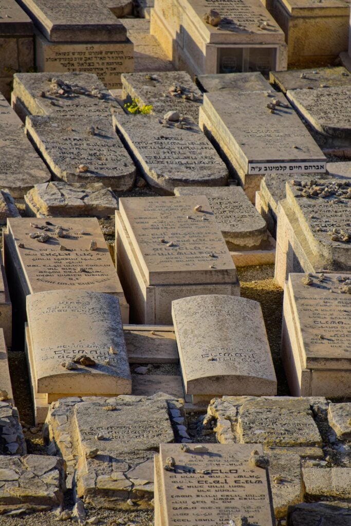 Image of stones with carvings of words laid out in Hebrew.