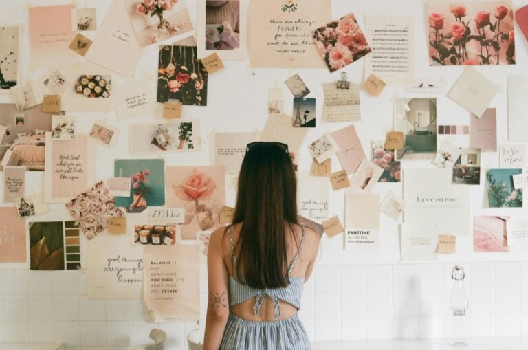 A woman standing in front of vision board.