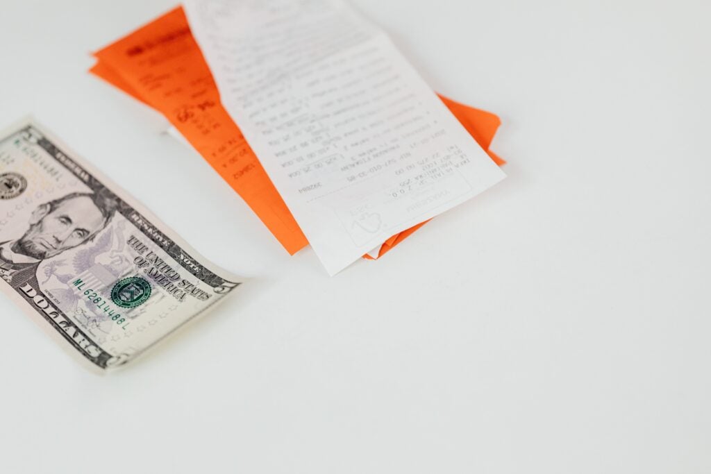 Notes and a dollar bill on a white table.