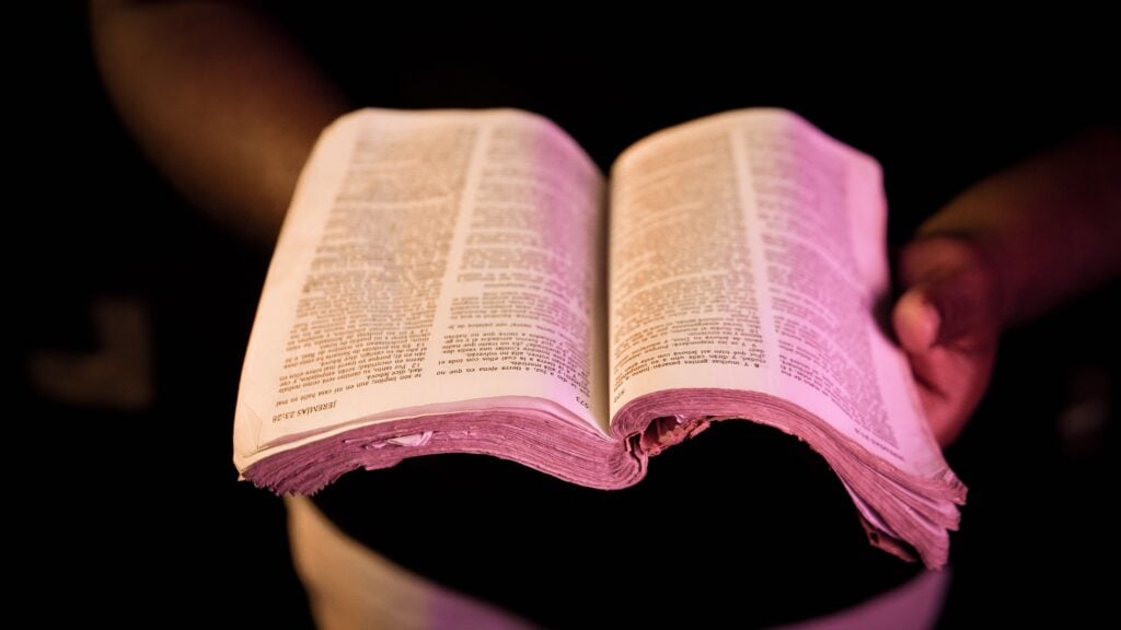 A man holding an open bible.