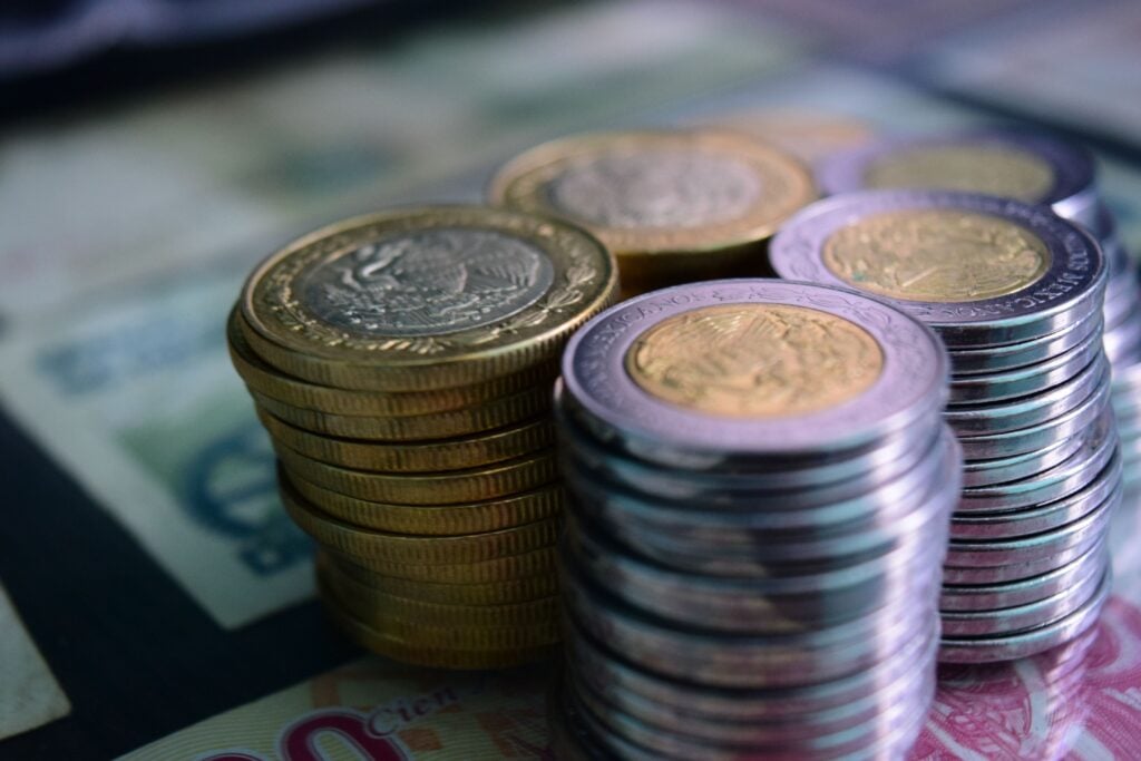Stacks of coins and cash on a table.