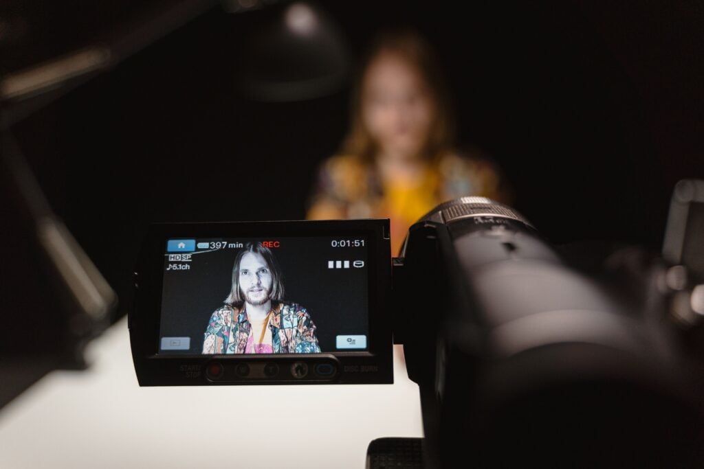A content creator filming with a camera.