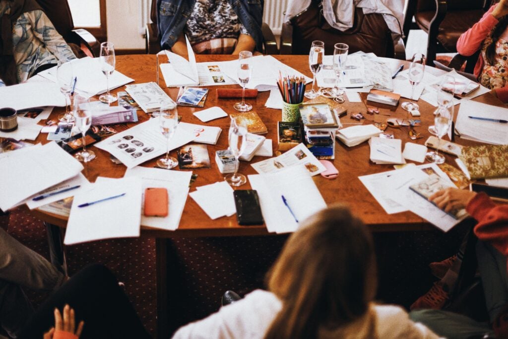 A group of people at a table with papers discussing. 
